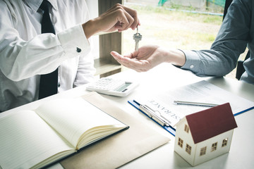 The capitalist is checking the property as collateral against the tenant to ensure that the tenant can rent the house and then give the key as the answer that the capitalist has approved the rent.