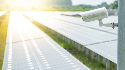 CCTV camera monitoring solar panels or polycrystalline silicon solar cells in the farm. Security in...