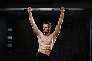 Boy doing exercise with bare torso looking at side.