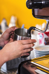 Barista steaming milk on a professional coffee machine. Closeup shot.