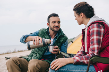couple drinking hot tea during camping