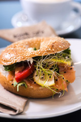 Morning meal, bagel burger with fresh salad and coffee. Gourmet conception.