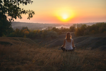 Girl meditating at sunset
