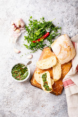  Argentinian green Chimichurri with ingredients.Raw homemade with ciabatta.Salsa or sauce made of parsley, garlic, oregano, hot pepper, olive oil, vinegar.Food Concept. Top View.Copy space for Text