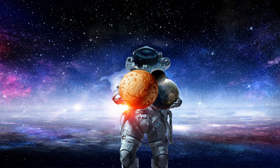 Fototapeta na wymiar Spaceman carry big planet. Mixed media