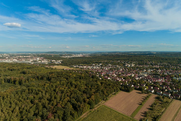 Luftbild mit Blick über Feld und Wald auf eine Stadt in Baden Württemberg
