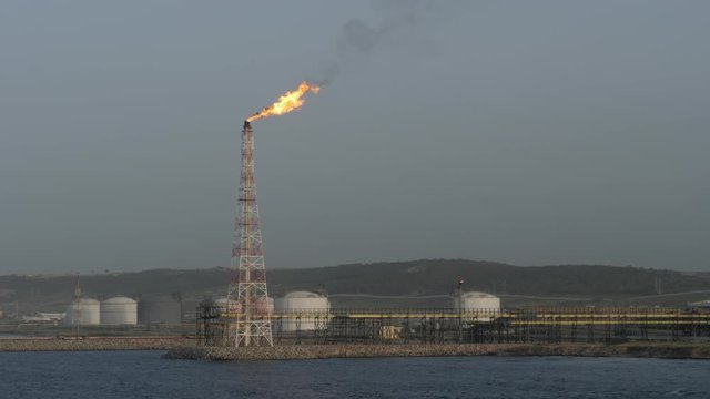 Flare stack of LNG refinery on sea shore