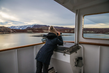 expedition participants is spotting the massive Icebergs floating in the fjord scoresby sund, east...