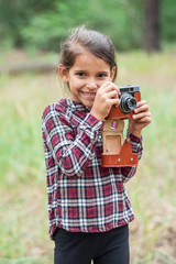 Young photographer. Small girl with camera.