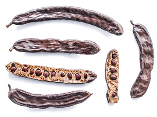 Carob pods and carob powder on the white background.