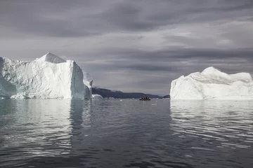 Foto op Plexiglas rubberboot cruisen voor enorme ijsbergen die in de fjord drijven scoresby sund, oost-Groenland © Mario Hagen