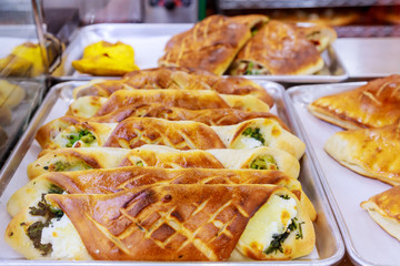 Fresh pastry to go and sandwiches with vegetables and meat in snack bar shop window