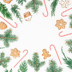 Frame made of gingerbread cookies, winter tree and candy cane on white background. Flat lay. top view. Christmas or New year holiday concept