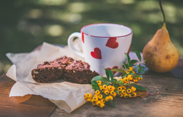 A cup of coffee and brownie cake with fall decoration