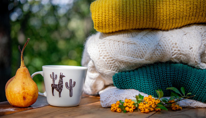 Fall decoration with a cup of coffee and wool clothes