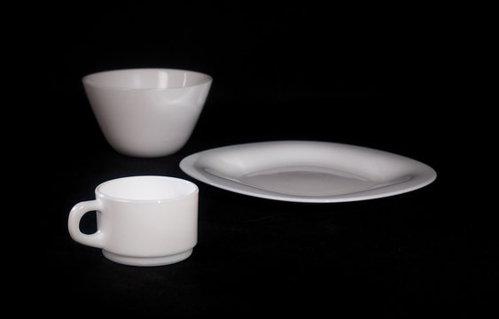 White plate with a mug on a black background