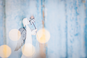 White angel Christmas decoration on blue background with lights