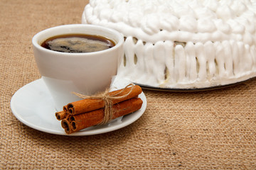 Cup of coffee, cinnamon and biscuit cake decorated with whipped cream
