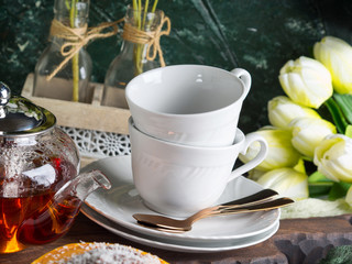 Hot tea in glass tea pot over green background. Moment of relax