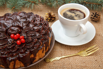 Chocolate cake decorated with bunch of viburnum and cup of coffee