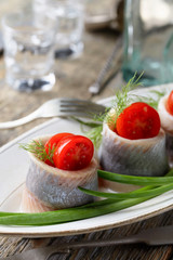 Herring rolls with dill , green onion and cherry tomatoes .