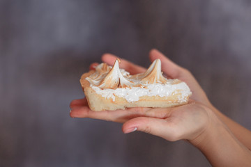 cake in the hands on a grey background