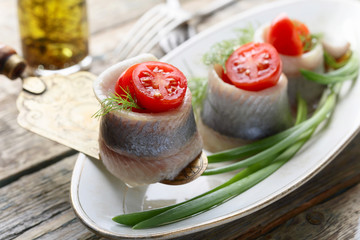 Herring rolls with dill , green onion and cherry tomatoes .
