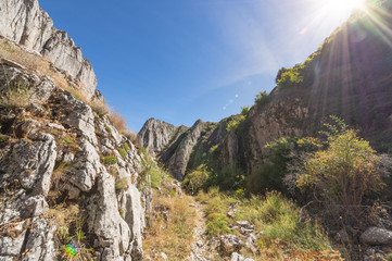 Narrow path between the mountain in the north of Leon (Spain), with the sun on top creating a fantastic effect of flare.