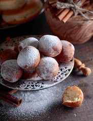 Sweet donuts with cinnamon sticks powdered with sugar.