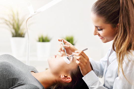 Adult woman having eyelash extension in professional beauty salon