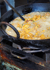 Indian street food vendor make pakodi,by deep frying in pan with oil