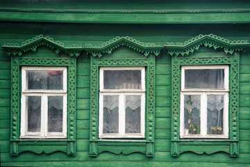 facade of the old Russian village wooden house with carved ornaments elements