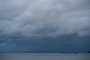 Fototapeta na wymiar Clouds loaded with rain over the sea, rainy background