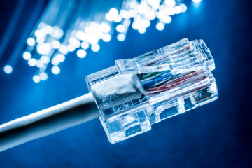 Network cable and optical fibers with lights in the ends at the background.