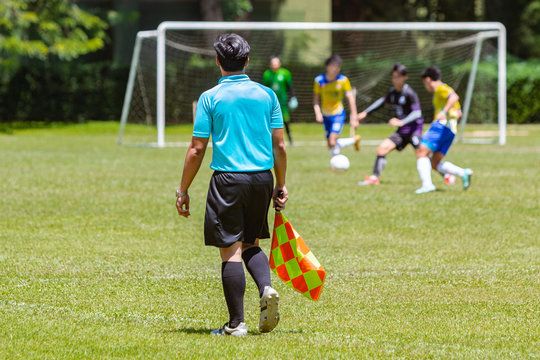 Soccer or football lineman referee watching a boy youth game