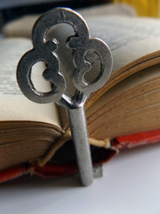 A key and an open old book