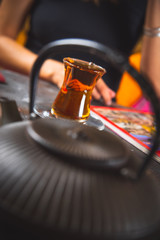A cup of tea is in front of a girl in the foreground of a Chinese teapot. Чашка чаю стоит перед девушкой на переднем плане китайский чайник.
