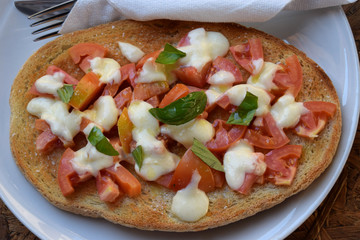 delicious italian starter without meat, bruschetta in an italian appetizer with tomatoes and mozzarella cheese and basil on toasted bread