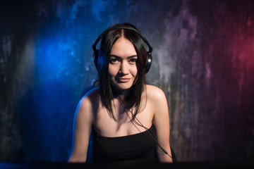 Portrait Shot of a Smiling Beautiful Professional Gamer Girl Playing in First-Person Shooter Online Video Game on Her Personal Computer. Casual Cute Geek Talking into Headset