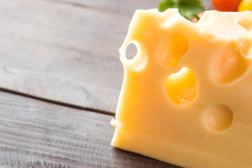 Cheese and tomatoes on dark wooden background with copy space