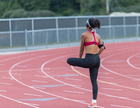 A young woman is stretching her legs after running