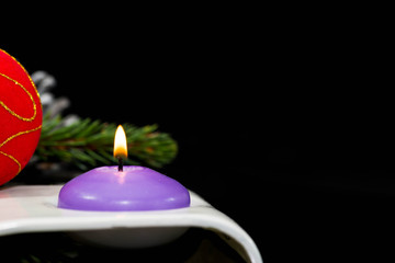 Christmas corner, candle light, decorations on black background, space for text.