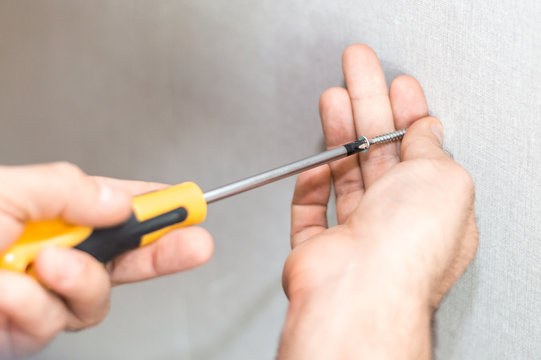 A man hands with screwdriver and screw