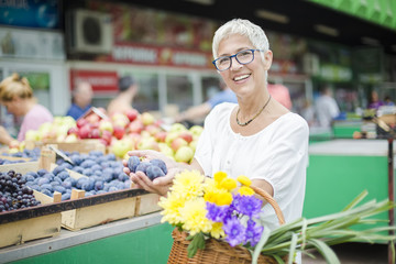 Senior woman buying fruit on market