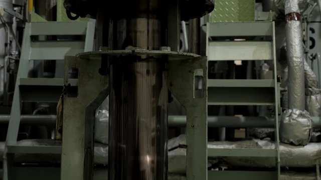 Used piston near diesel engine of ship