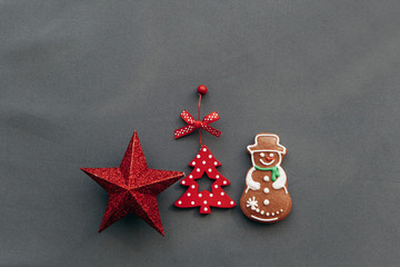 Christmas toys and gingerbread in the shape of a snowman on a gray background. Christmas or New Year's concept.