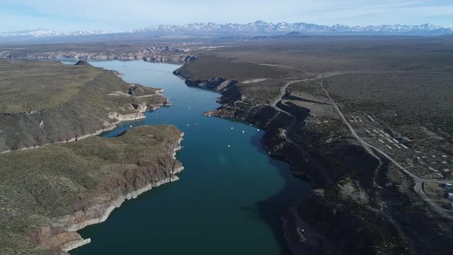 Aerial drone scene of Agua de Toro lake at San Rafael, Mendoza, Cuyo Argentina. Camera moving fowards and descending with complete view of lake and high snowy plata mountains at background