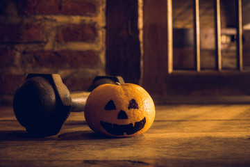 Orange with Head Pumpkins  haunted spooky face  with black iron dumbbell. Halloween Festival with...