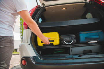 hands load bags in car trunk © phpetrunina14