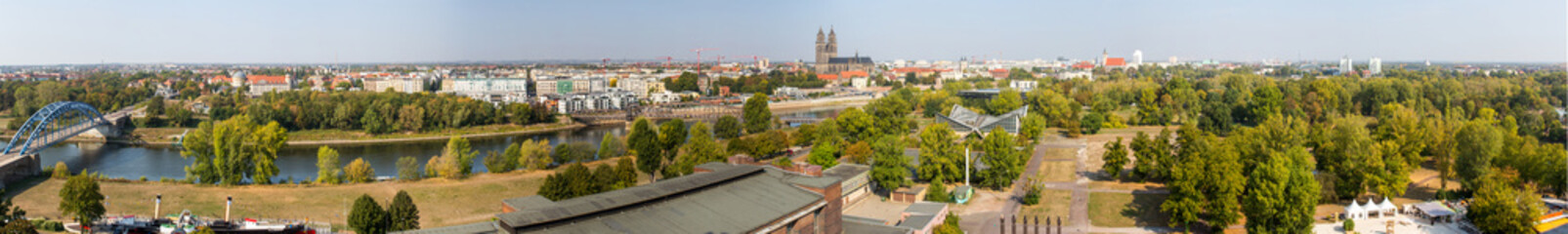 Fototapeta premium Panorama von Magdeburg mit Elbbrücken, Sternbrücke, Elbe, Dom, Grüne Zitadelle, Jahrtausendturm, Stadthalle, Stadtpark Rotehorn im Sommer von Oben 